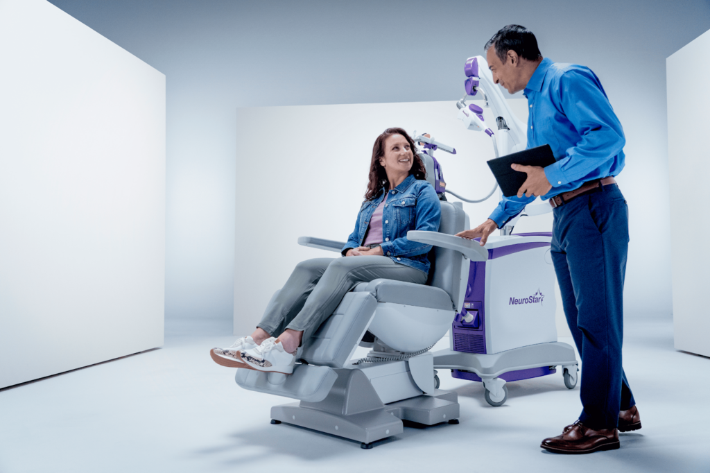 What Is TMS Therapy demonstrated as a patient sits in a NeuroStar chair while a clinician explains the procedure