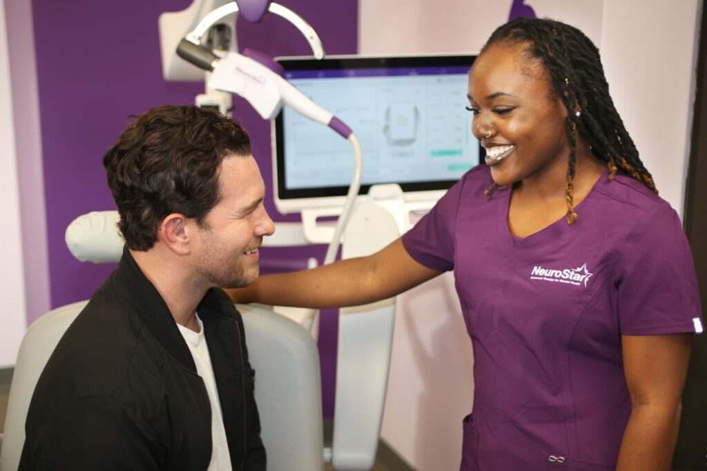 Does Insurance Cover TMS Therapy? A NeuroStar clinician consulting a male patient before his TMS session.